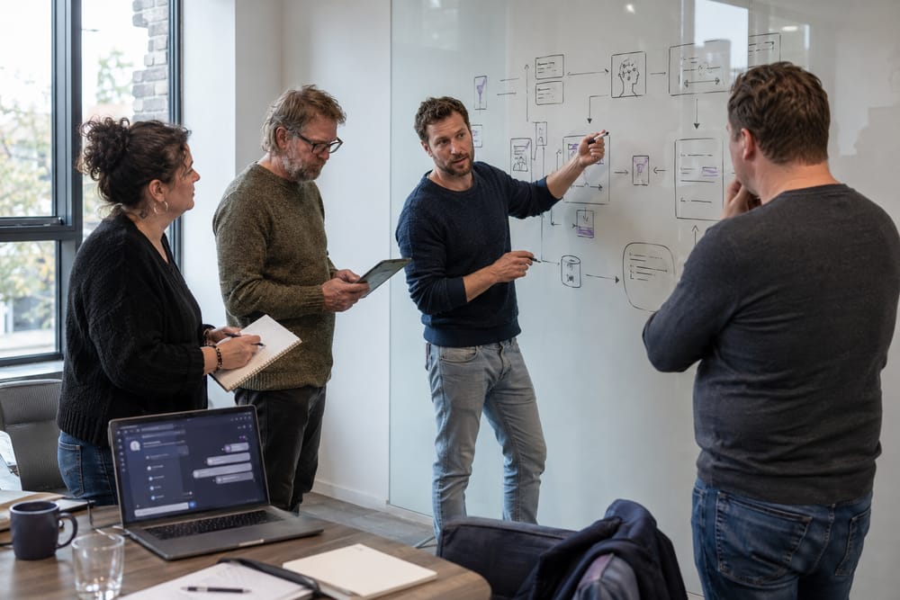 Trainer legt aan een whiteboard een AI-workflow uit aan cursisten tijdens de AI-cursus