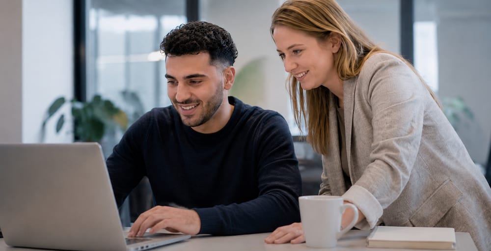 Twee cursisten kijken samen naar een laptopscherm tijdens de training