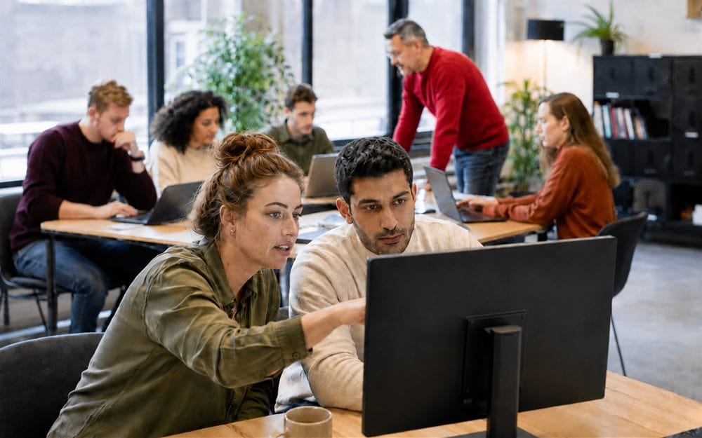 Groep cursisten werkt aan PHP-code voor een webapplicatie tijdens een praktijkgerichte PHP-training van Global Training
